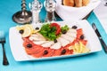 Mediterranean fish sliced Ã¢â¬â¹Ã¢â¬â¹salmon, tuna and trout with vegetables, greens, lemon and black olives Royalty Free Stock Photo